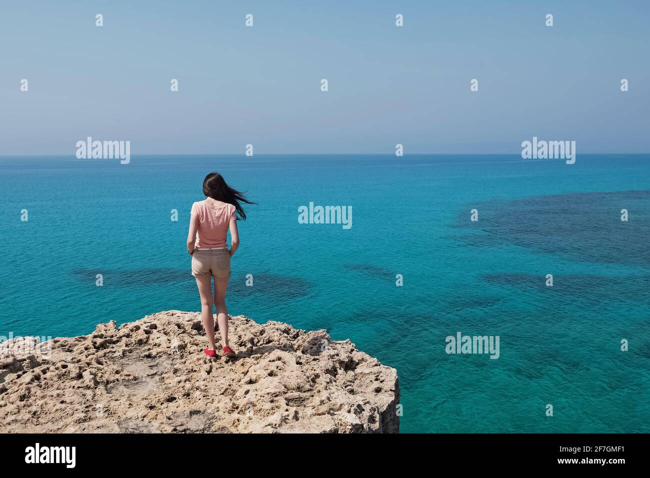 Junge Frau auf der Klippe mit schöner Aussicht t stehen Stockfoto