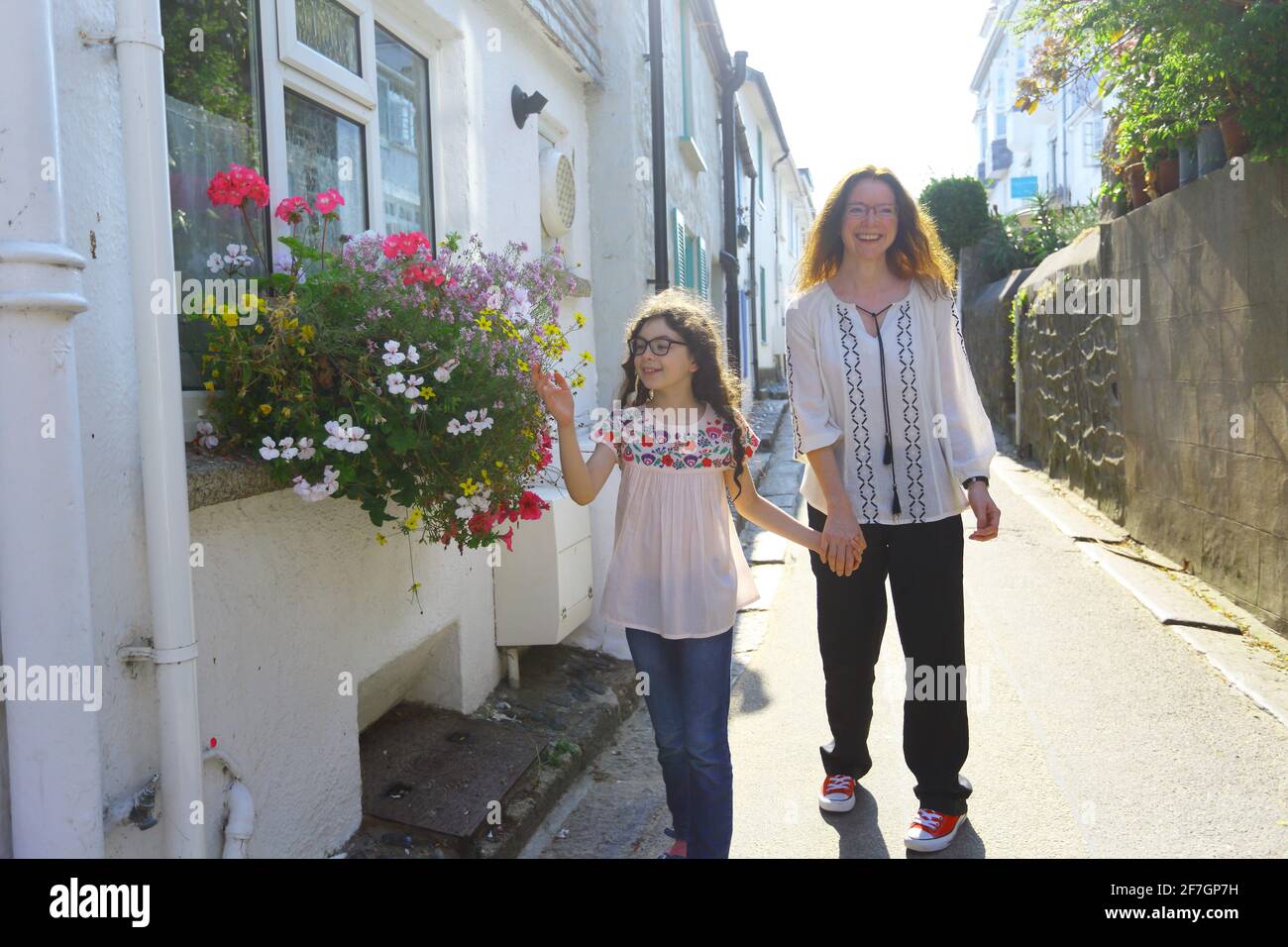 Sonniger Morgen Sommertag, Mutter und Tochter halten die Hände fest Schmale Straße St Ives Cornwall, Großbritannien Stockfoto