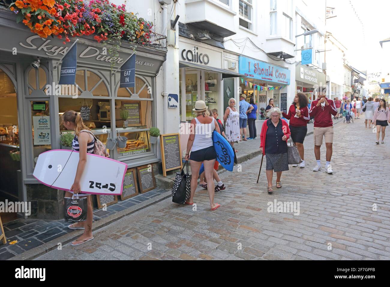 Geschäfte in einer gepflasterten Straße, die von Touristen in St. Ives, Cornwall, England, Großbritannien, frequentiert ist Stockfoto