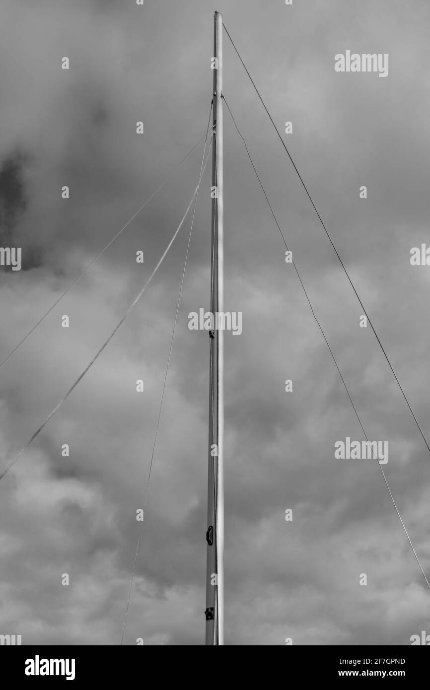 Der Mast eines Bootes gegen einen wolkigen Himmel. Stockfoto