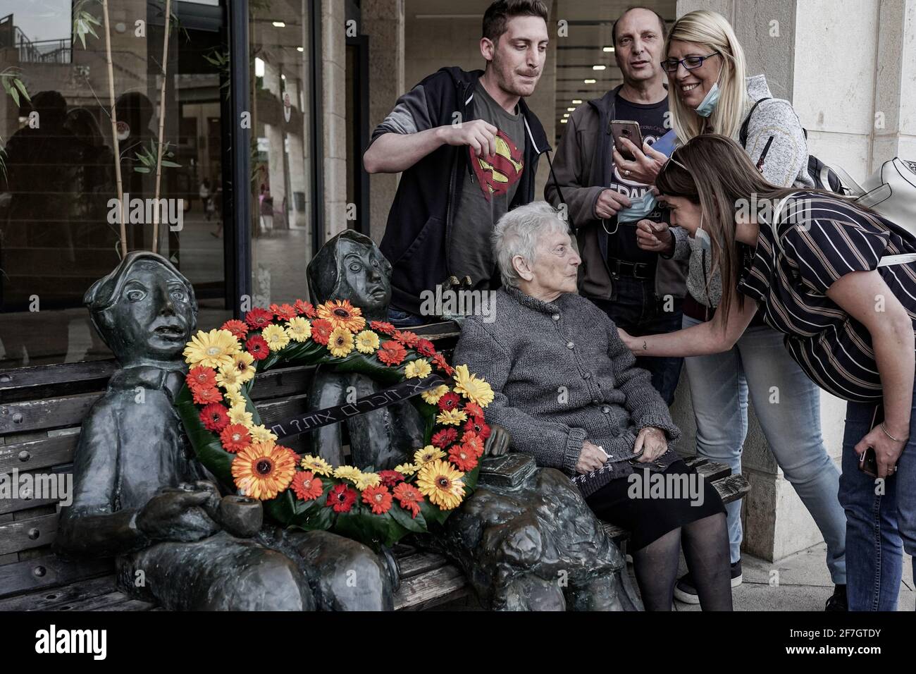 Jerusalem, Israel. April 2021. Die Familie und Ehefrau des Bildhauers, Dr. Martin Kieselstein, legten einen Blumenkranz auf die Tischstatue des Bildhauers, die dem Gedenken aller Großmütter und Großväter unter den sechs Millionen jüdischen Opfern des Holocaust am Vorabend des Gedenktages der Märtyrer und Helden des Holocaust, Jom HaShoah, gewidmet ist. Kredit: Nir Alon/Alamy Live Nachrichten Stockfoto