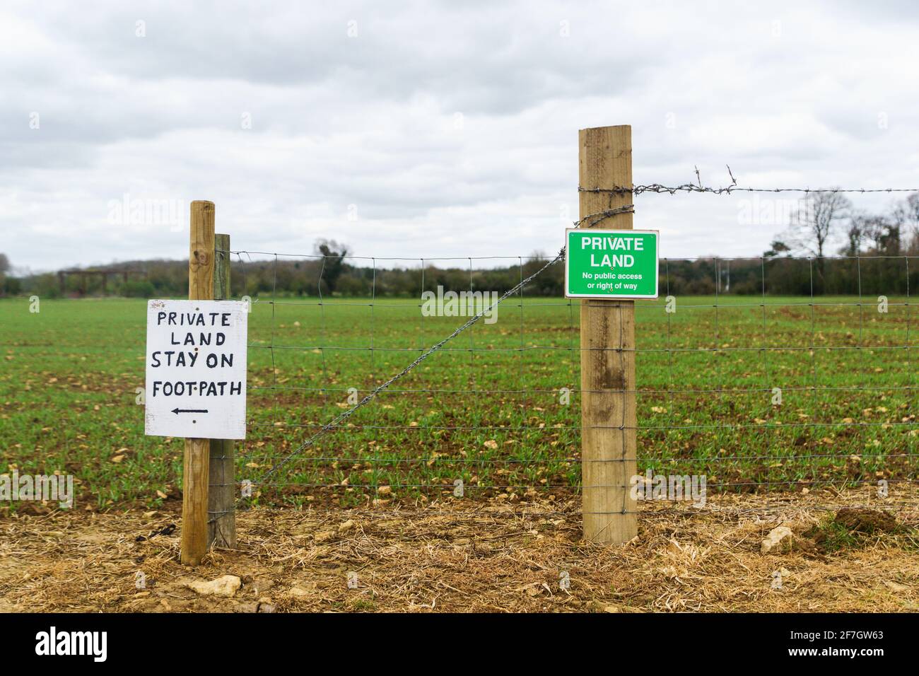 „Privatland“, „Stay on Footpath“-Schilder entlang eines öffentlichen Wegs, das durch Ackerland führt. Oxfordshire, Großbritannien Stockfoto