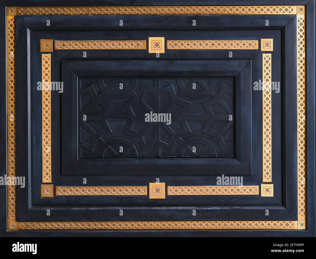 Geometrisches Design Fragment der modernen Luxus schwarze Holz Eingangstür mit geschnitzten Panel und goldenen Patina-Rahmen mit klassischen Orient-Muster. Stockfoto
