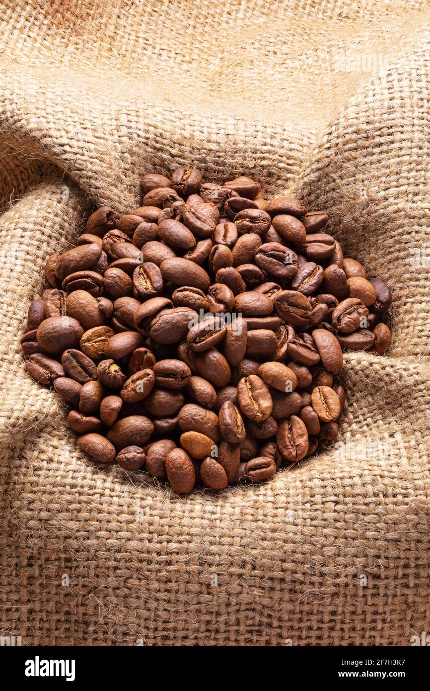 Kaffeebohnen auf Sackleinen Hintergrund Stockfoto