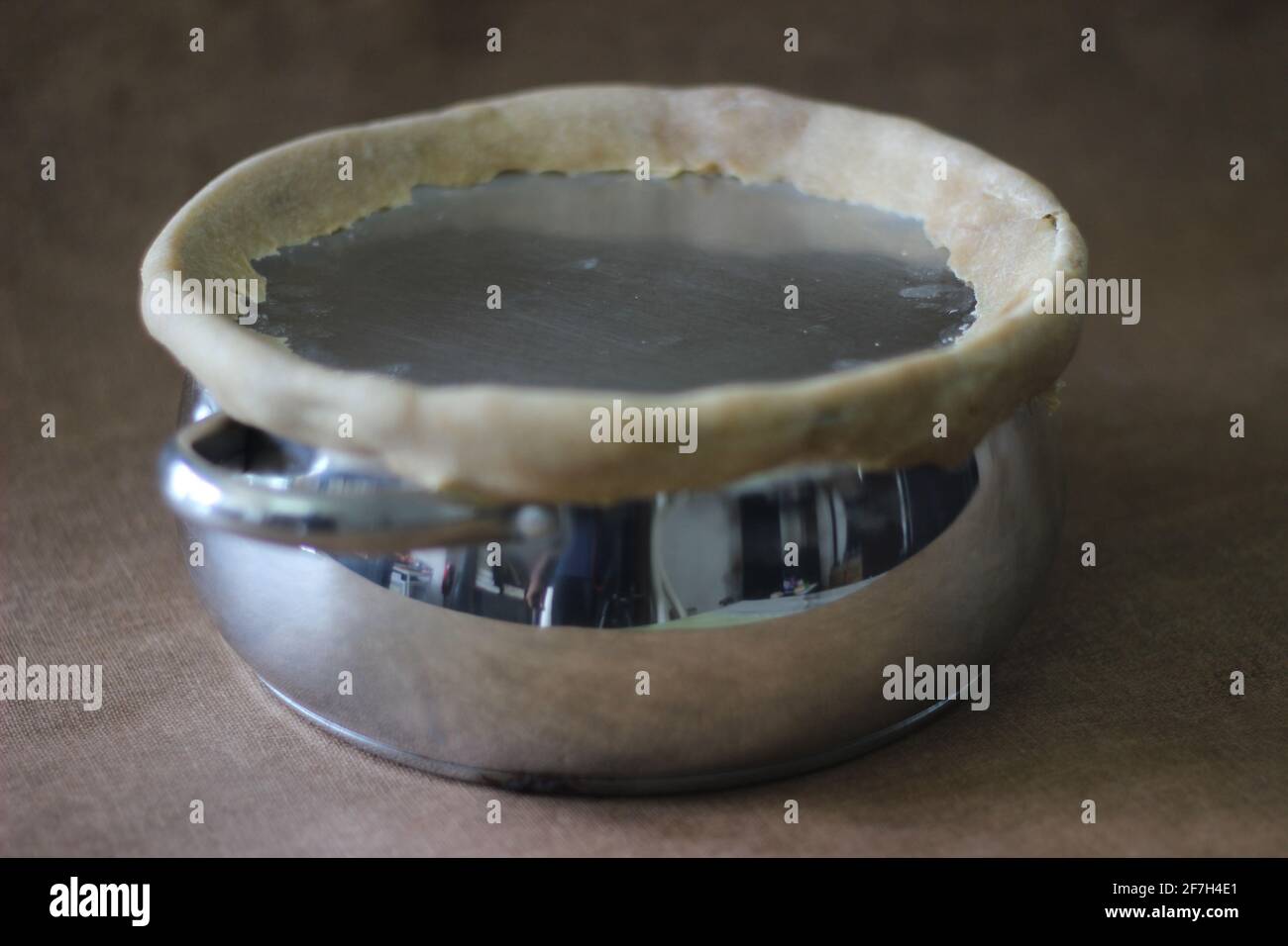 Topf mit versiegelten Kanten mit Mehlteig langsam kochen den Reis. Die Kanten sind versiegelt, um das Entweichen des Dampfes zu verhindern. Eine Methode zur Vorbereitung von Biriyani Stockfoto
