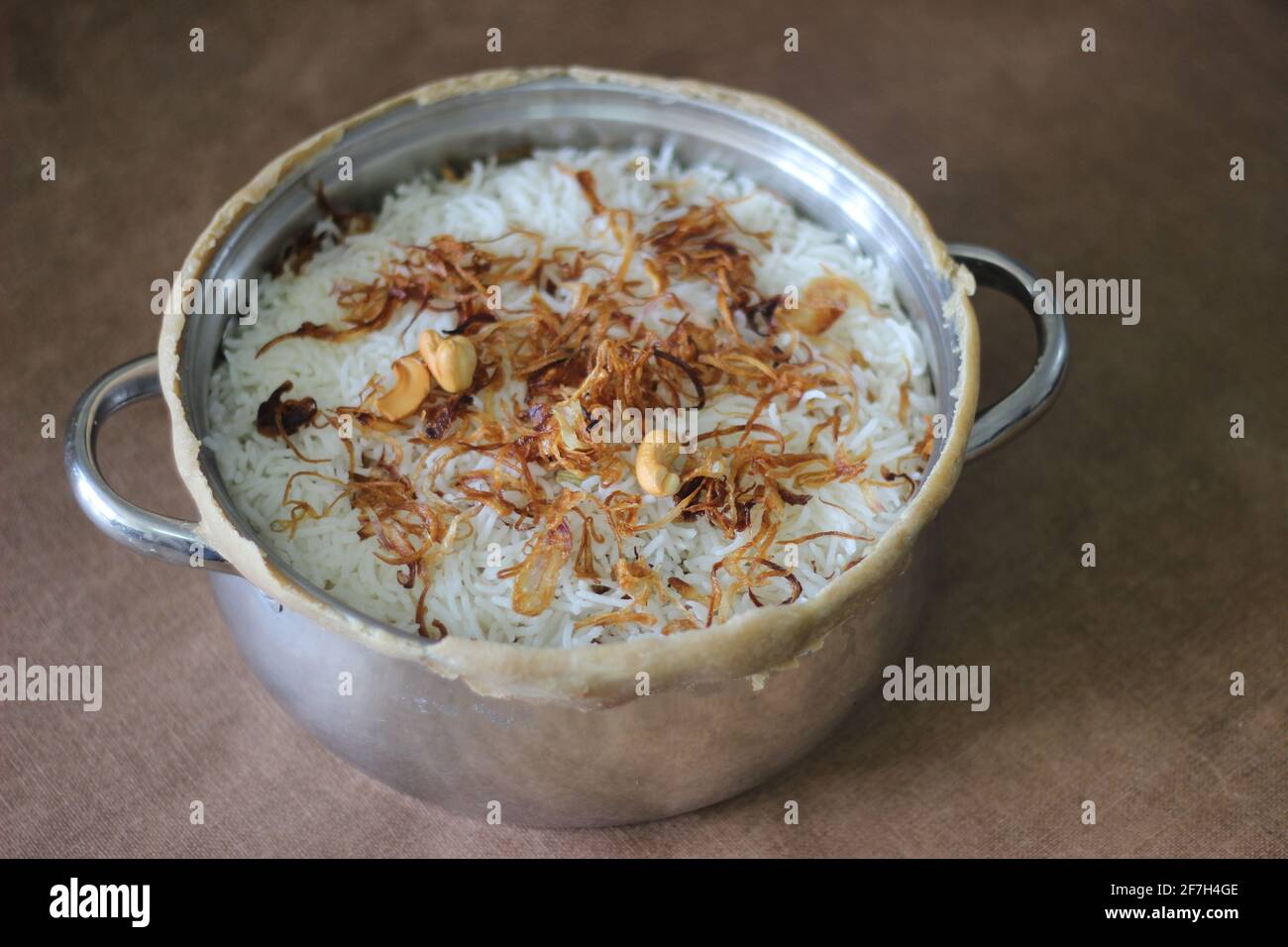 Hammelfleisch biriyani im offenen Topf nach dem Brechen der versiegelten Kanten. Die Ränder wurden versiegelt, um den Reis langsam zu kochen. Eine Methode zur Vorbereitung von Biriyani Stockfoto