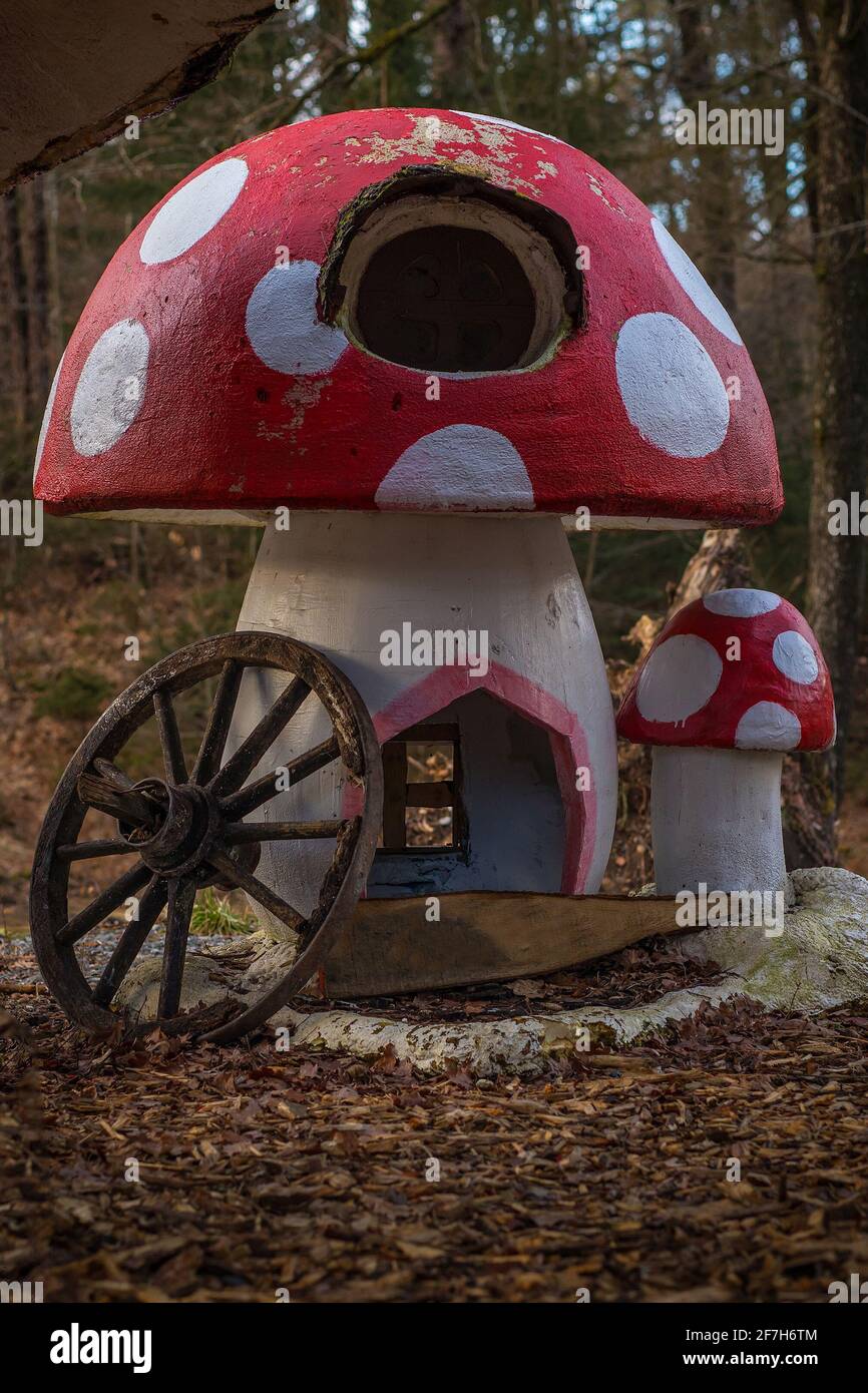 Echtes Pilzhaus in einer ländlichen Umgebung. Pilzförmige Fantasie oder Kinderspielhaus in einem verzauberten Wald. Rotes Dach mit weißen Punkten. Stockfoto