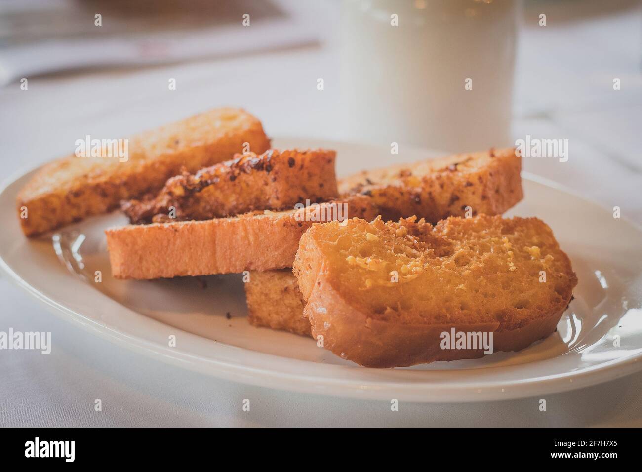 Scheiben gebratenes Brot auf einem weißen Teller. Gemeinsames Frühstück in bestimmten Teilen europas, auch bekannt als Snite. Stockfoto