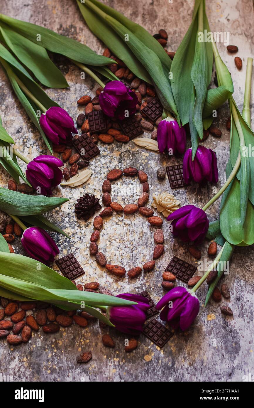 8. märz, internationaler Frauentag, acht davon aus Kakaobohnen mit violetten Tulpen und handgefertigten Pralinen Stockfoto
