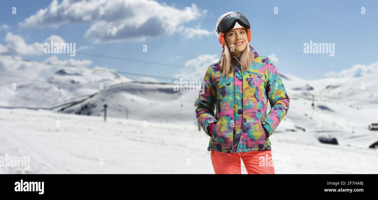 Junge Frau in Winterskikleidung posiert auf dem Berg Pisten Stockfoto