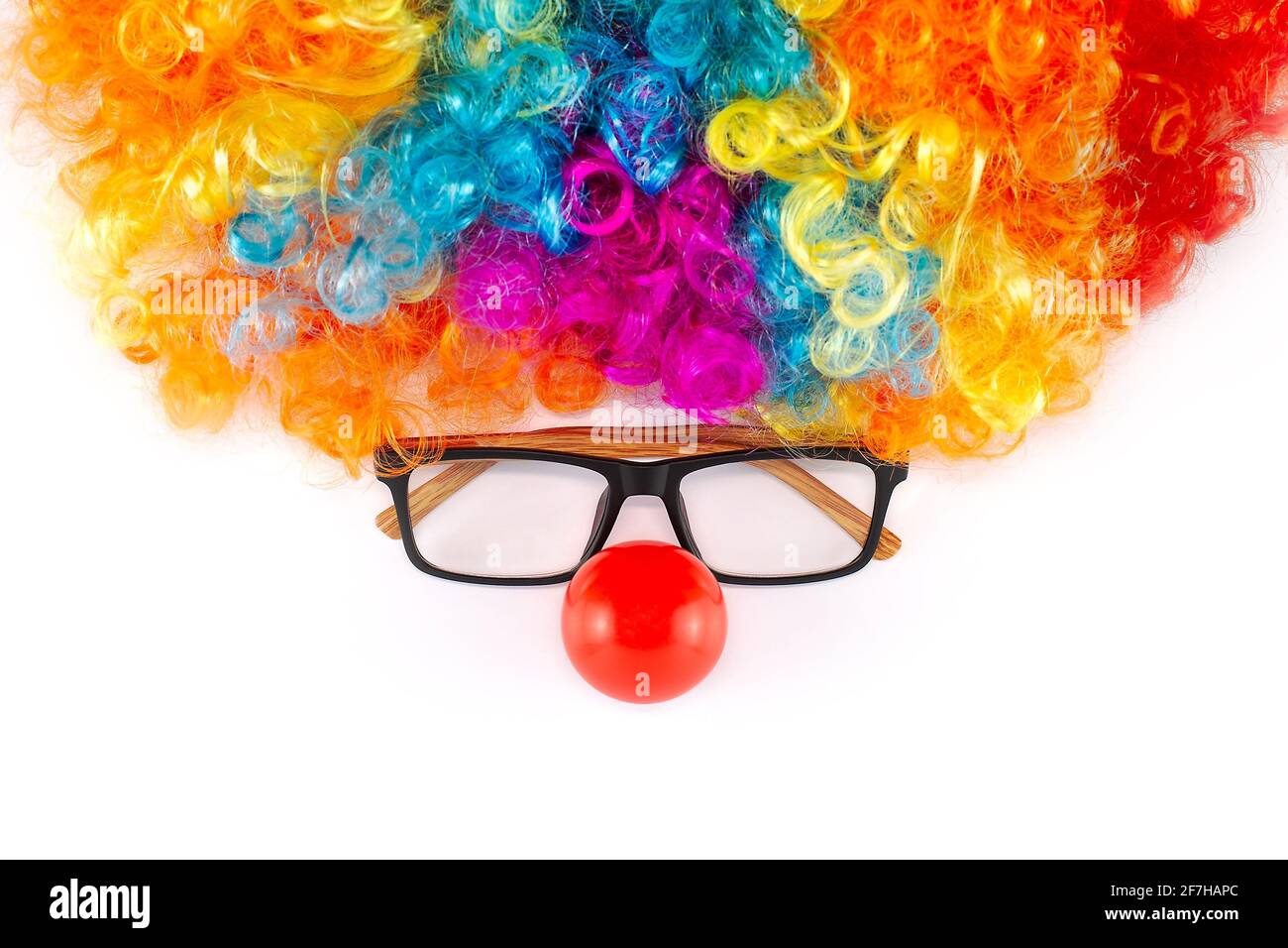 Lustige Party Konzept Gesicht gebildet. Regenbogen Clown Perücke Set mit Brille und rote Clown Nase wie ein Gesicht, flauschige Afro Synthetisch Cosplay Anime Fancy Perücken Stockfoto