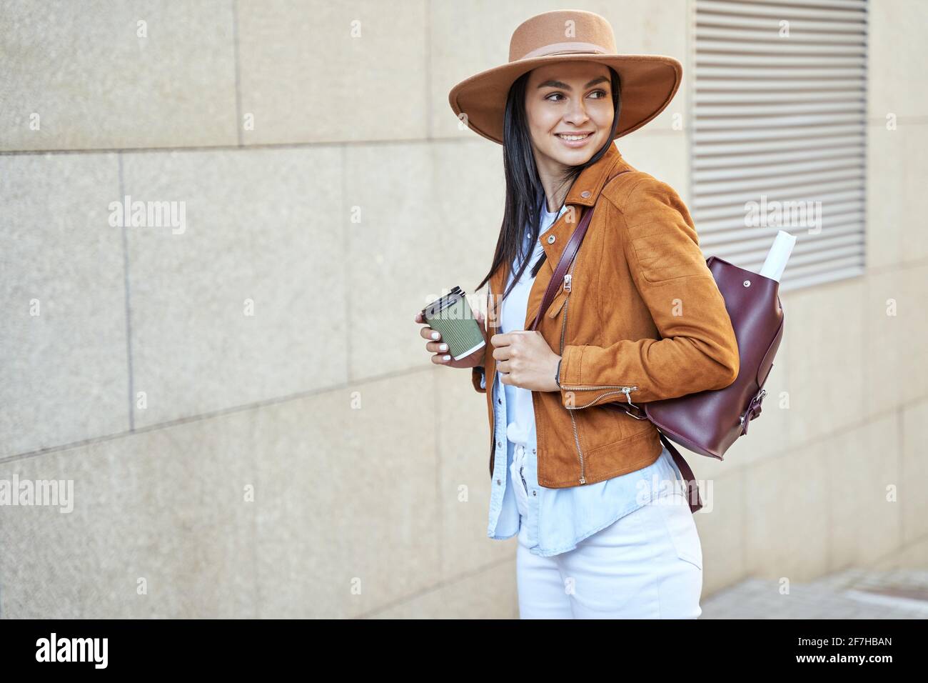 Stilvolle hübsche Dame mit Rucksack und Heißgetränk im Freien Stockfoto