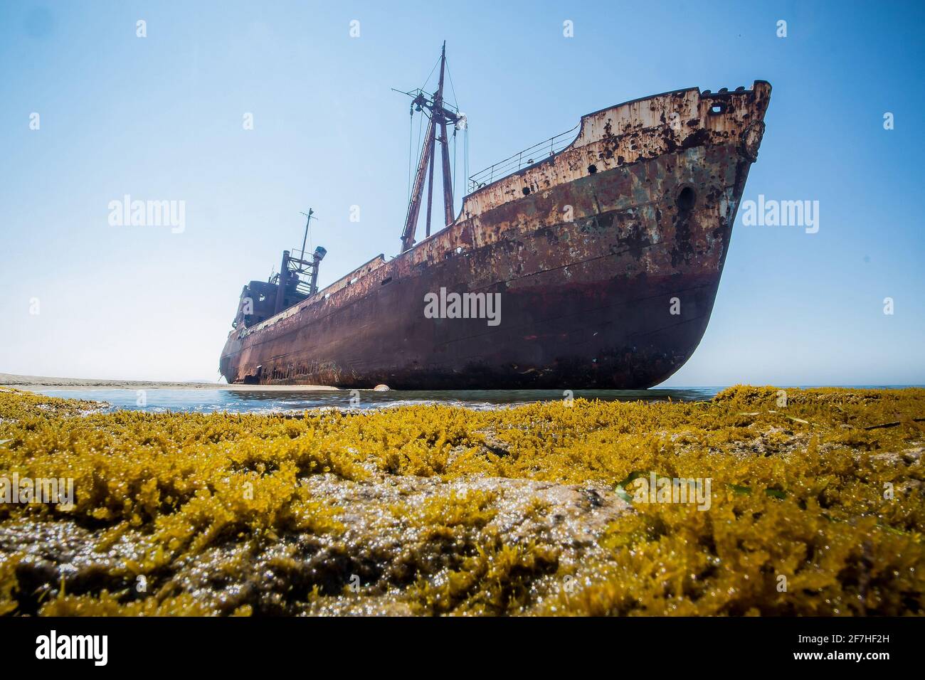 Dimitrios Schiffbruch in Gythio, Griechenland. Ein teilweise versunkenes rostiges Schiffswrack aus Metall, das an einem sonnigen Tag an einem Sandstrand durch die Zeit verfällt. Berühmtes Schiffswrack Stockfoto
