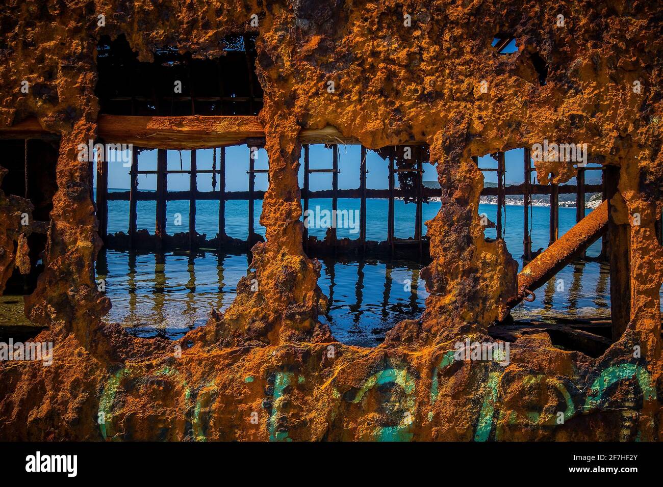 Innenansicht des Schiffswracks von Dimitrios in Gythio, Griechenland. Ein teilweise versunkenes rostiges Schiffswrack aus Metall, das an einem sonnigen Tag an einem Sandstrand durch die Zeit verfällt. Famo Stockfoto