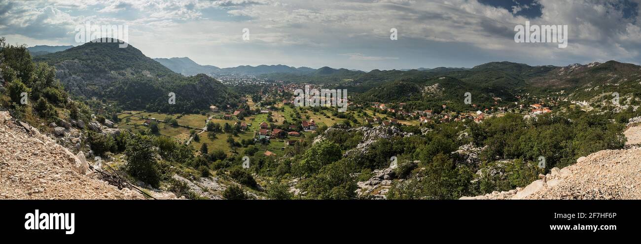 Panorama von Cetinje, der ehemaligen Hauptstadt Montenegros. Blick auf die Häuser von cetinje, die sich in grünen Hügeln und Wäldern verstecken. Einige Felsen im f Stockfoto