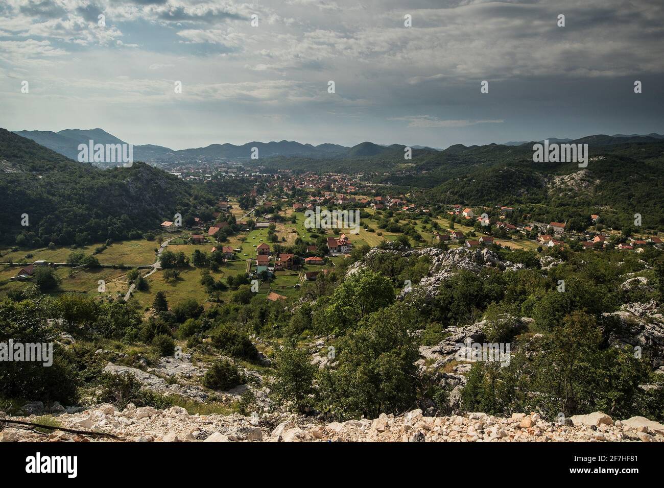 Panorama von Cetinje, der ehemaligen Hauptstadt Montenegros. Blick auf die Häuser von cetinje, die sich in grünen Hügeln und Wäldern verstecken. Einige Felsen im f Stockfoto