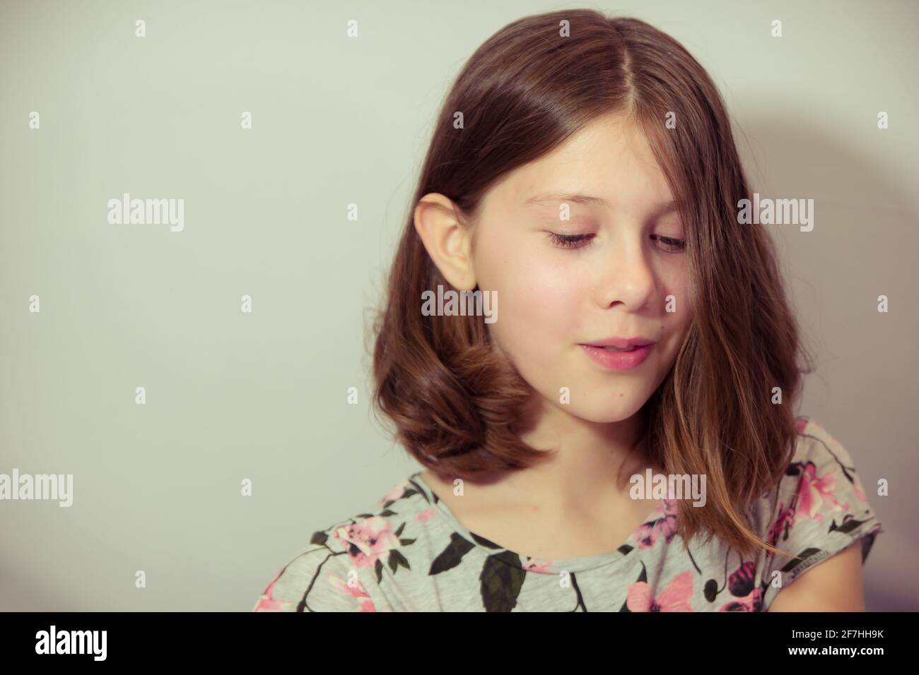 Tween Mädchen schaut mit spitzbübisch Ausdruck - mit weiß Platz Stockfoto