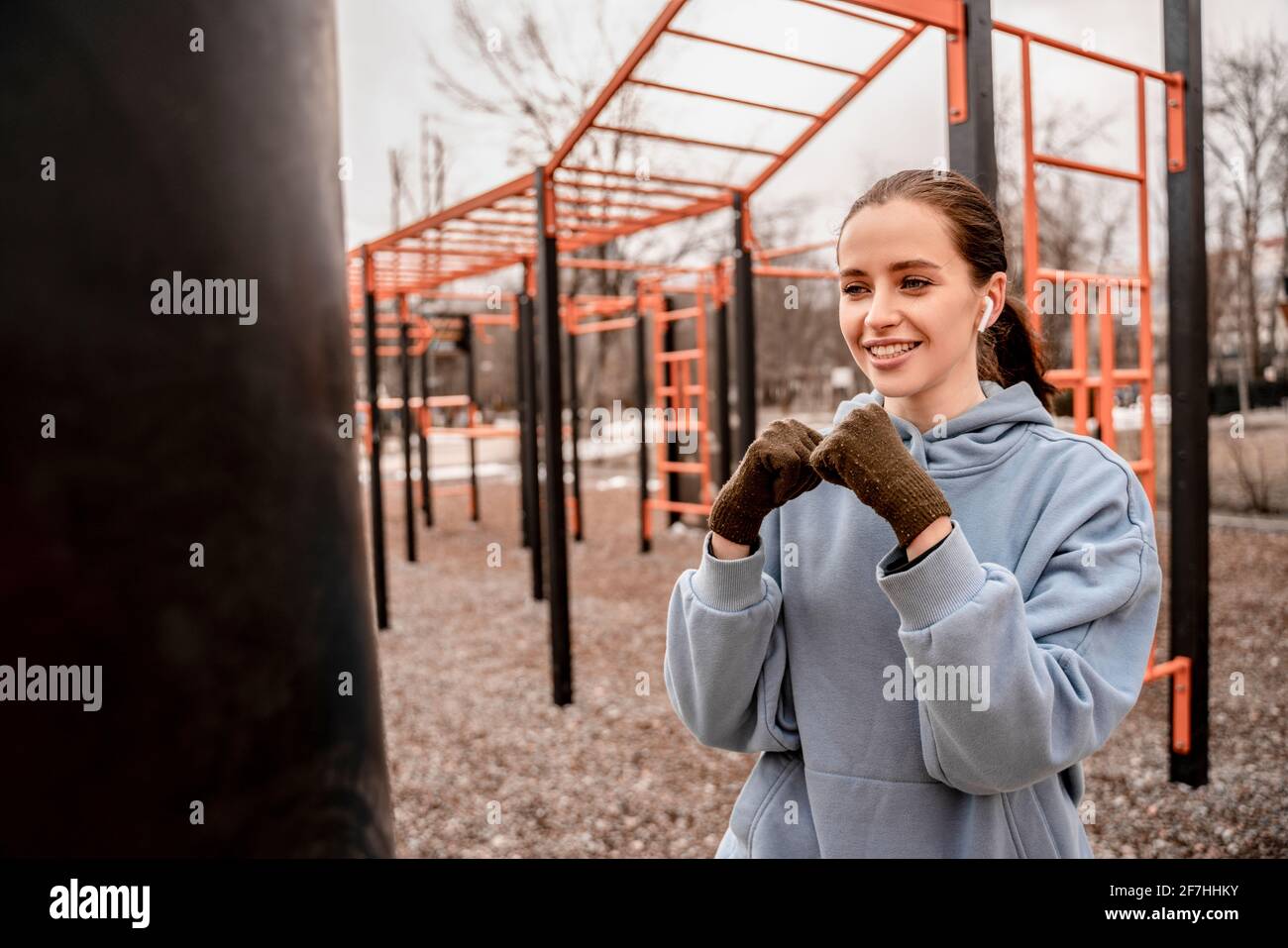 Junge Frau im Sportoutfit macht morgens Workout im Freien. Junge weibliche Boxen auf dem Straßensportplatz. Fit und gesund bleiben Konzept Stockfoto