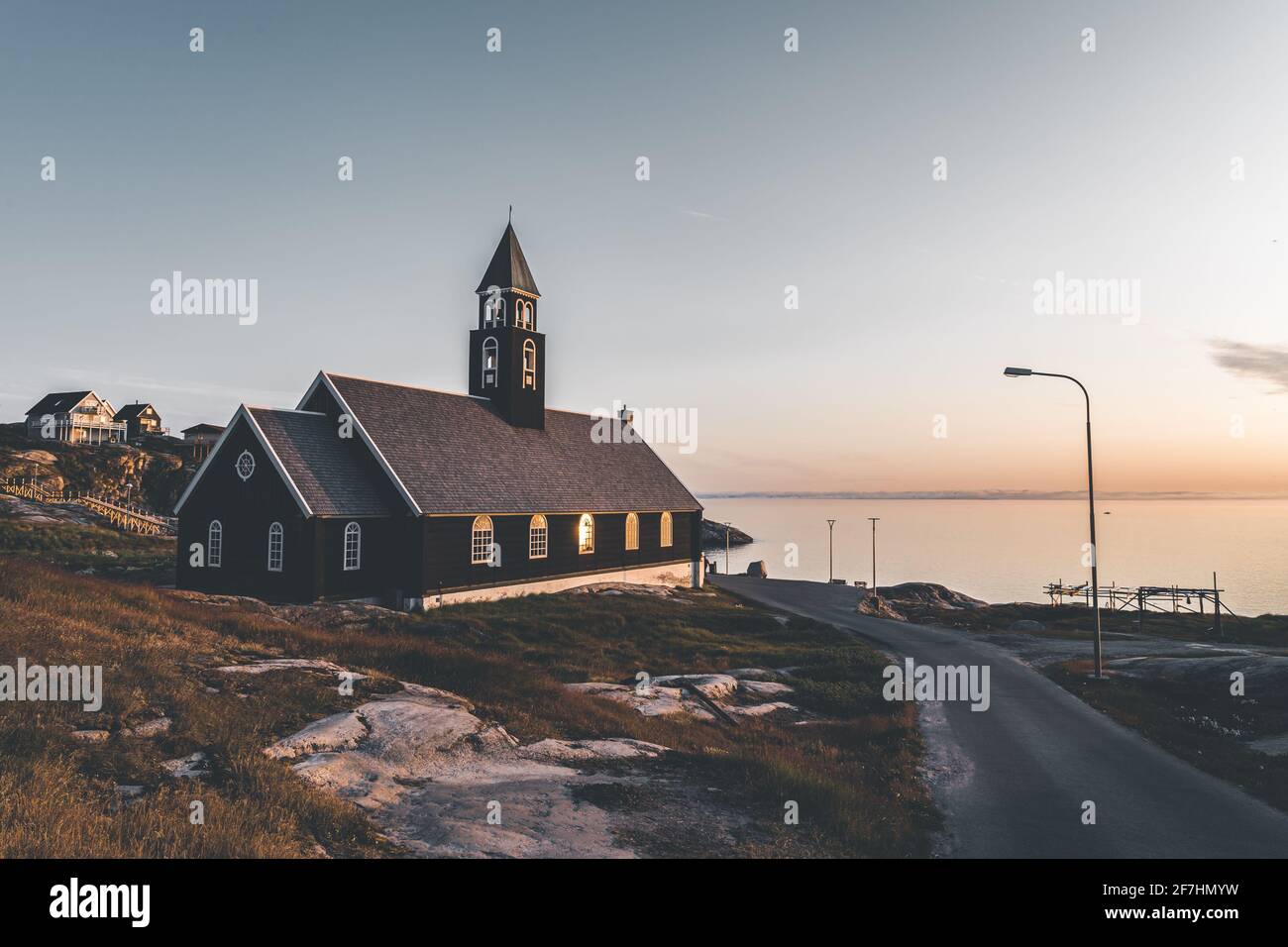 Alte hölzerne Zions-Kirche in der arktischen Stadt Ilulissat, mit Mitternachtssonnenlicht und blauem Himmel in Nordgrönland Stockfoto