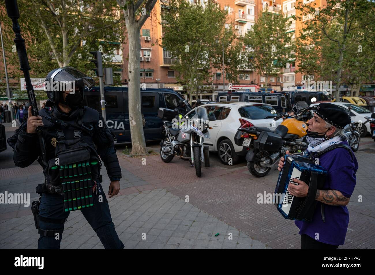 Madrid, Spanien. April 2021. Eine Frau mit einem Akkordeon vor einer Bereitschaftspolizei während einer Kundgebung der rechtsextremen VOX-Partei im Stadtteil Vallecas. DIE VOX-Partei stellt ihre Kandidatur für die nächsten Regionalwahlen in Madrid vor, an denen Nachbarn des Distrikts Vallecas teilgenommen haben, um gegen die rechtsextreme Partei zu protestieren. Quelle: Marcos del Mazo/Alamy Live News Stockfoto