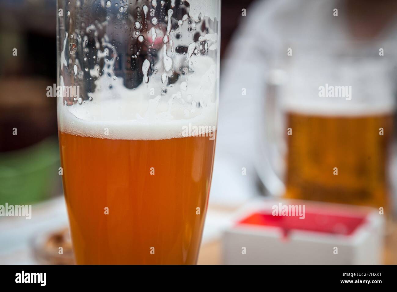 Nahaufnahme und selektive Unschärfe auf einem Bierkrug mit einem Weizenbier im Stil von Weissenbier, serviert in einem Standard-Glas in Pint-Größe Bild eines Bierkrug mit Stockfoto