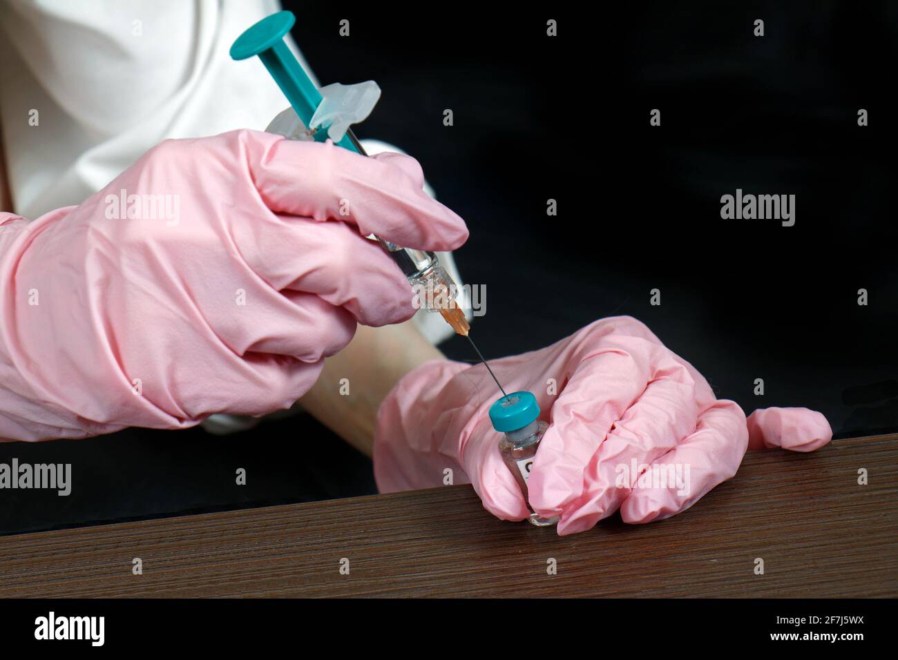 Krankenschwester mit Latexhandschuhen, Schutzspritze mit Covid-19-Impfstoff Vor dem Einspritzen Stockfoto