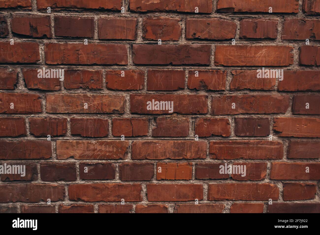 Die Textur einer alten Ziegelmauer mit natürlichen Defekten. Kratzer, Risse, Spalten, Späne, Staub, Rauheit, Abrieb. Vorlage für Design und Stockfoto