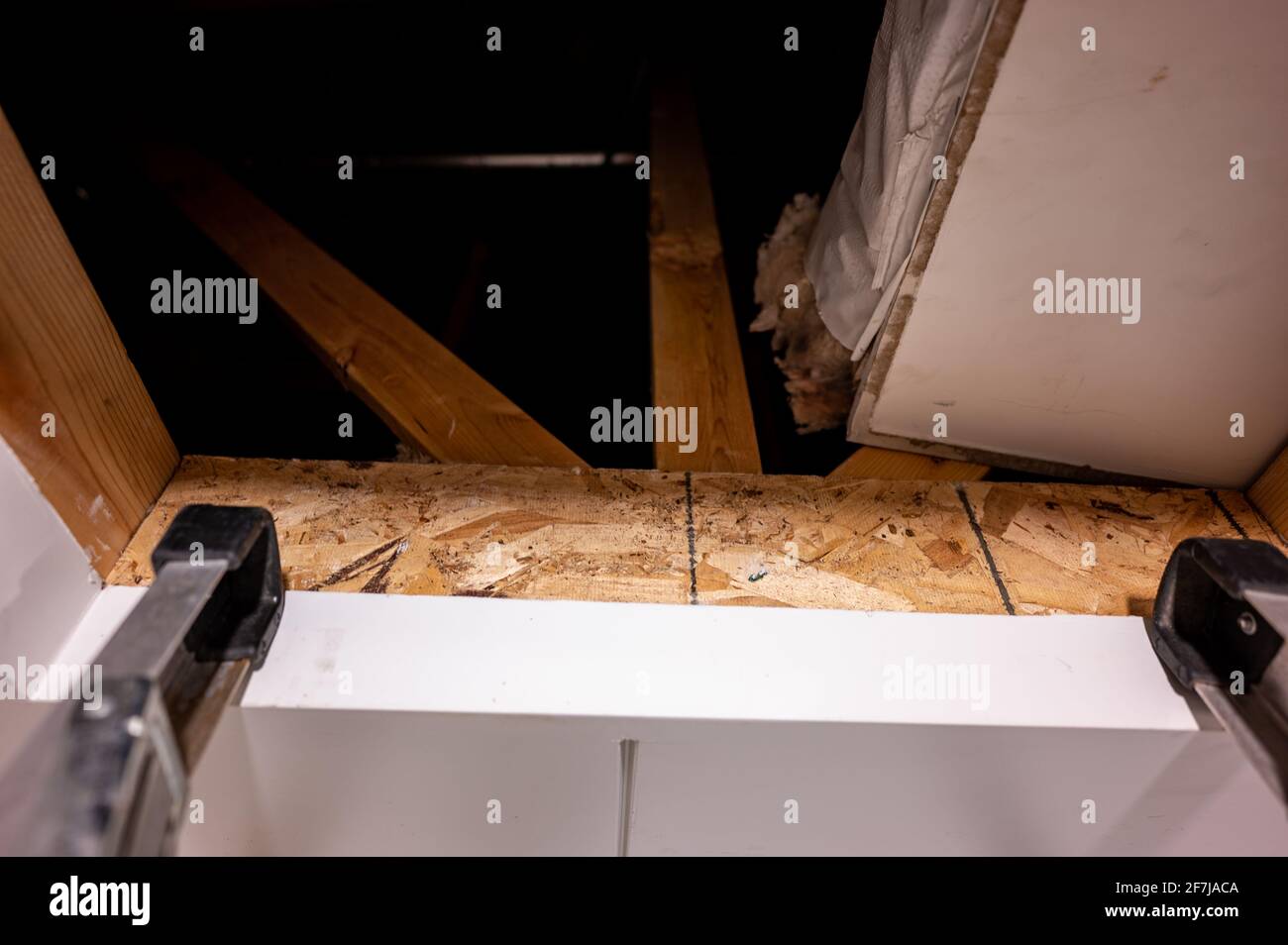 Letzte Sprosse einer Leiter unter einem offenen Dachboden-Eingang Stockfoto
