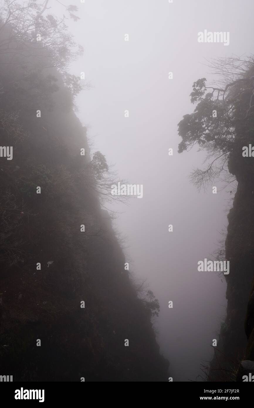 V-Form Tal in starkem Nebel. Stockfoto