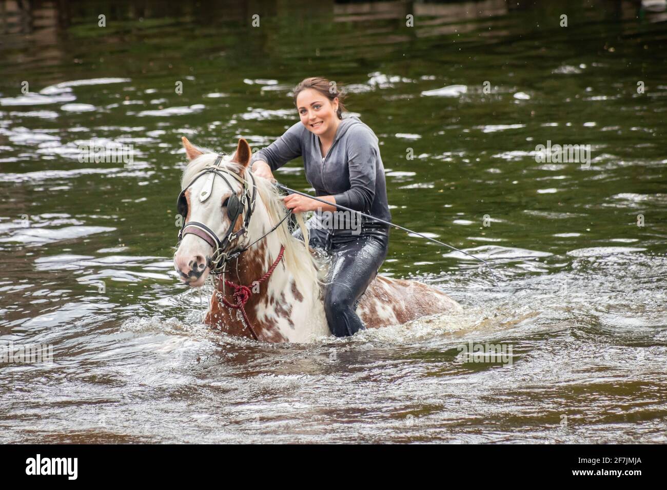 Junge Zigeunerfrau auf dem Pferd im Fluss in Appleby Pferdemesse Cumbria Stockfoto