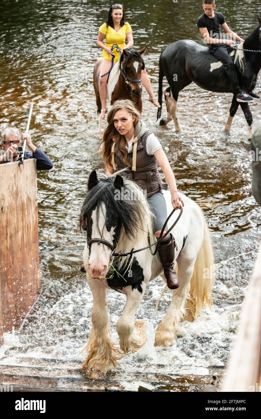 Junge Zigeunerfrau auf dem Pferd im Fluss in Appleby Pferdemesse Cumbria Stockfoto