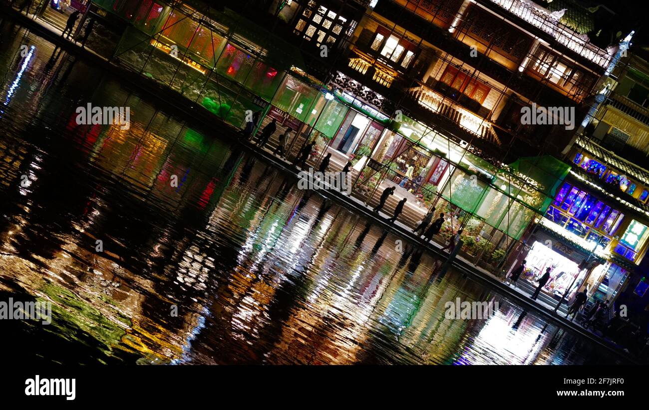 Kleine Stadt mit Licht an und ihre Reflaktion auf dem Wasser in Neigungswinkel. Stockfoto