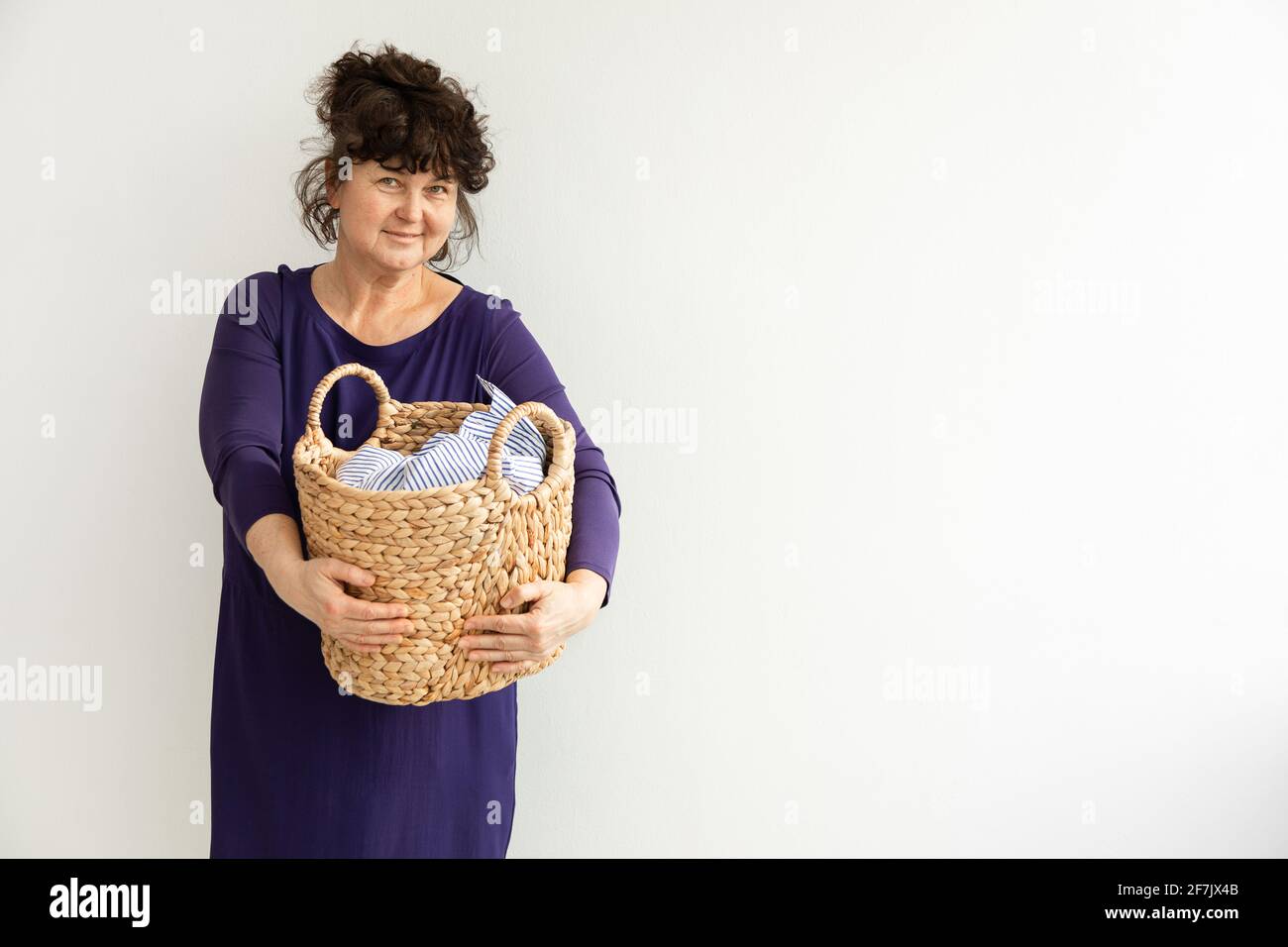 Erwachsene Brünette Frau hält Korb schmutzige Wäsche. Konzept Housekeeping.Copy Raum Stockfoto