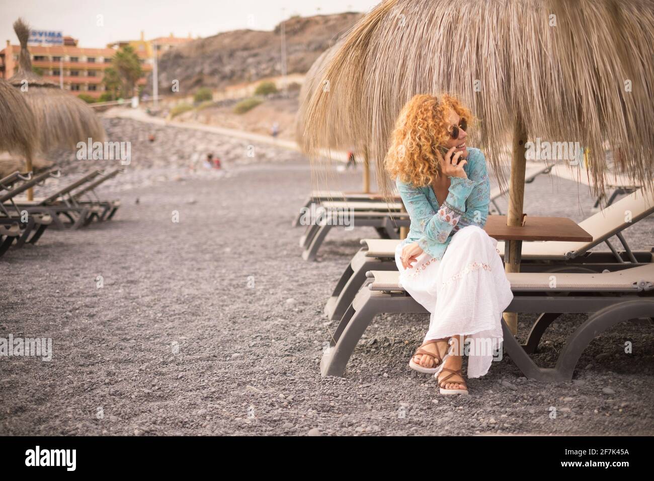 Erwachsene hübsche Frau setzen sich auf ein Sonnenbett Der Strand mit dem Handy, um Freunde anzurufen - Leute Weibliche und Frühlingsferien Urlaub allein - cheef Stockfoto Erwachsene hübsche Frau setzen sich auf ein Sonnenbett Der Strand mit dem Handy, um Freunde anzurufen - Leute Weibliche und Frühlingsferien Urlaub allein - cheef Stockfoto