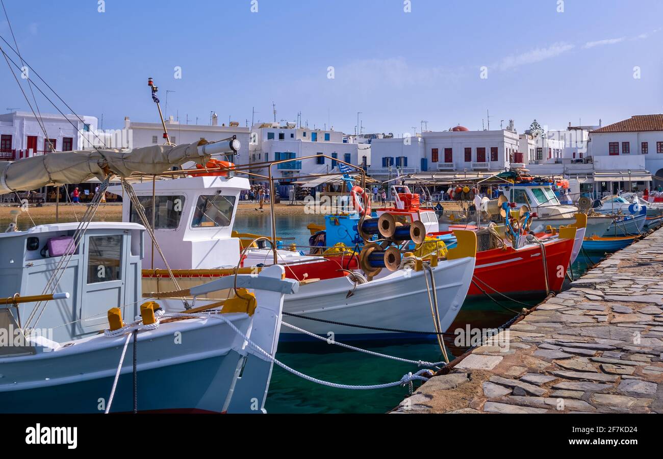 Schöner Sommertag, Yachthafen der griechischen Insel. Fischerboote liegen an der Anlegestelle. Mykonos, Kykladen, Griechenland. Weiß getünchte Häuser. Mediterraner Lebensstil. Stockfoto