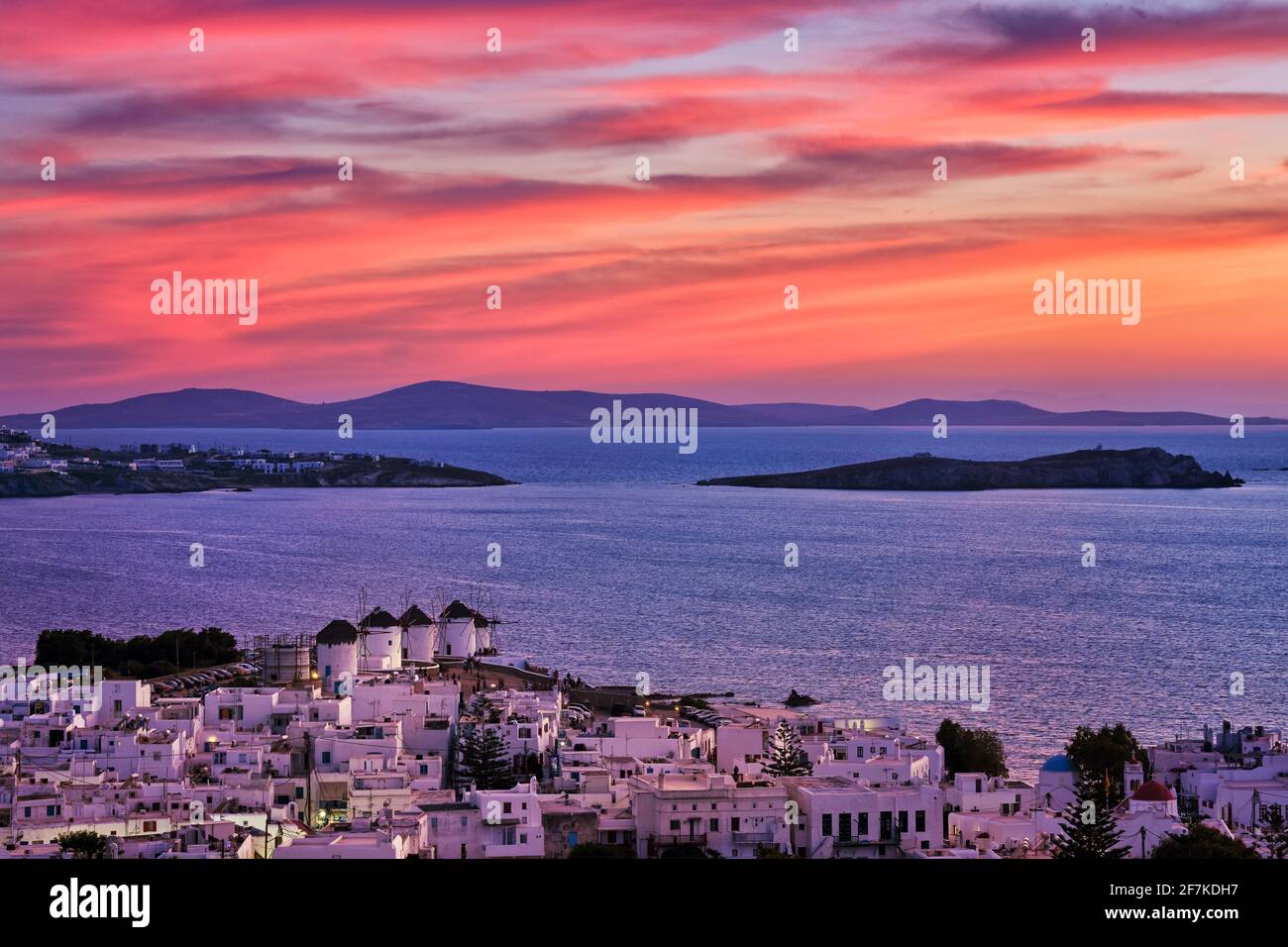 Wunderschöne Sonnenuntergangsansicht der berühmten traditionellen weißen Windmühlen, Mykonos, Kykladen, Griechenland. Weiß getünchte Häuser, farbenprächtiger Sonnenuntergang, trübe Sommerabende Stockfoto