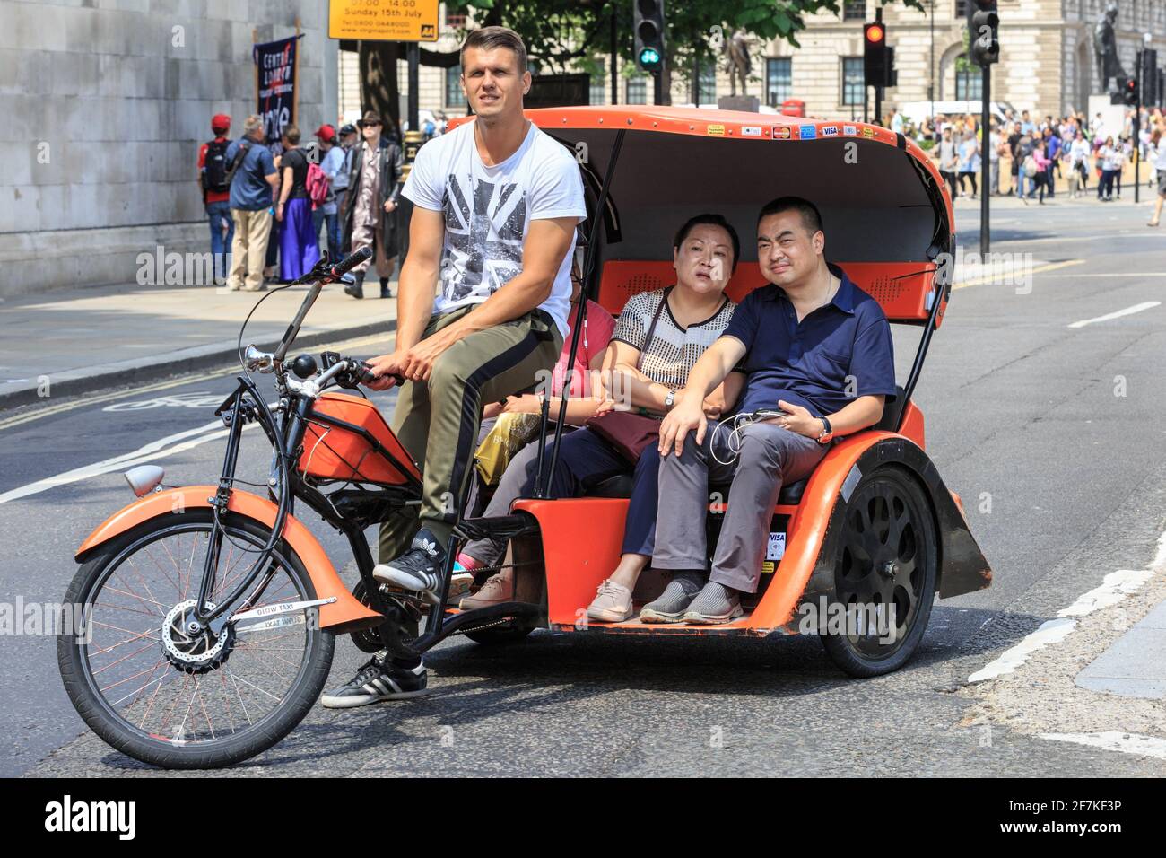 Asiatische Touristen auf einer Fahrrad-Rikscha (Fahrrad-Taxi oder Pediküre) in Westminster, London, England Stockfoto