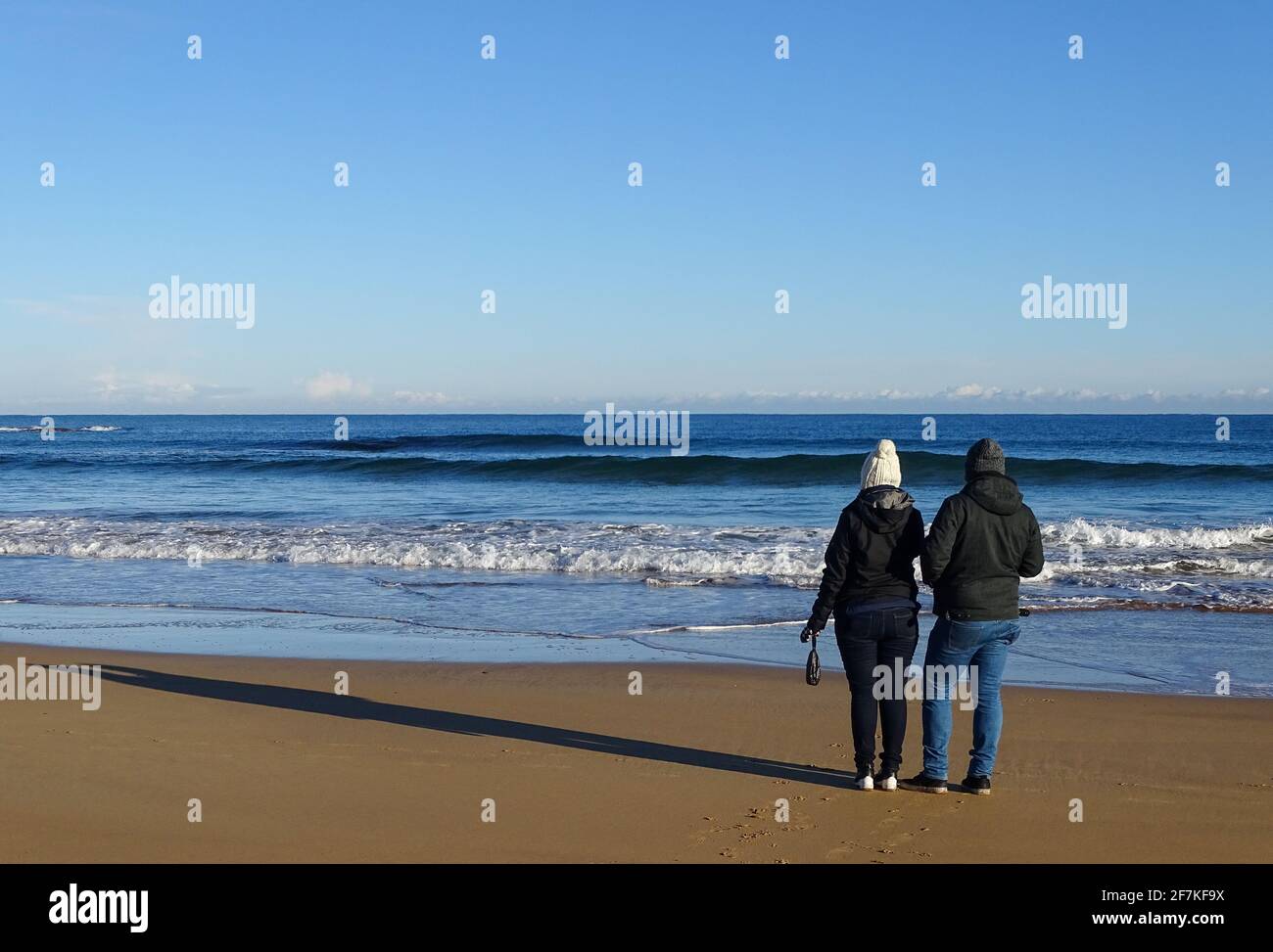 Paar, das im Sand steht, am irischen Strand, Irland Reiseziel, während der Reise. Stockfoto