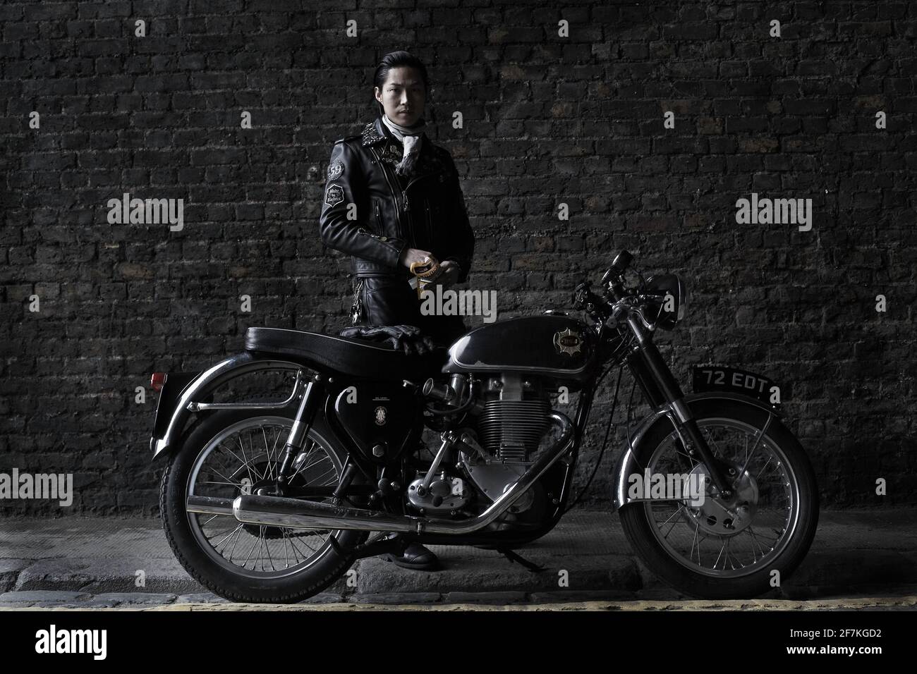 Biker, Cafe Racer trägt schwarze Lederjacke hinter klassischen britischen Motorrad in London, Großbritannien Stockfoto
