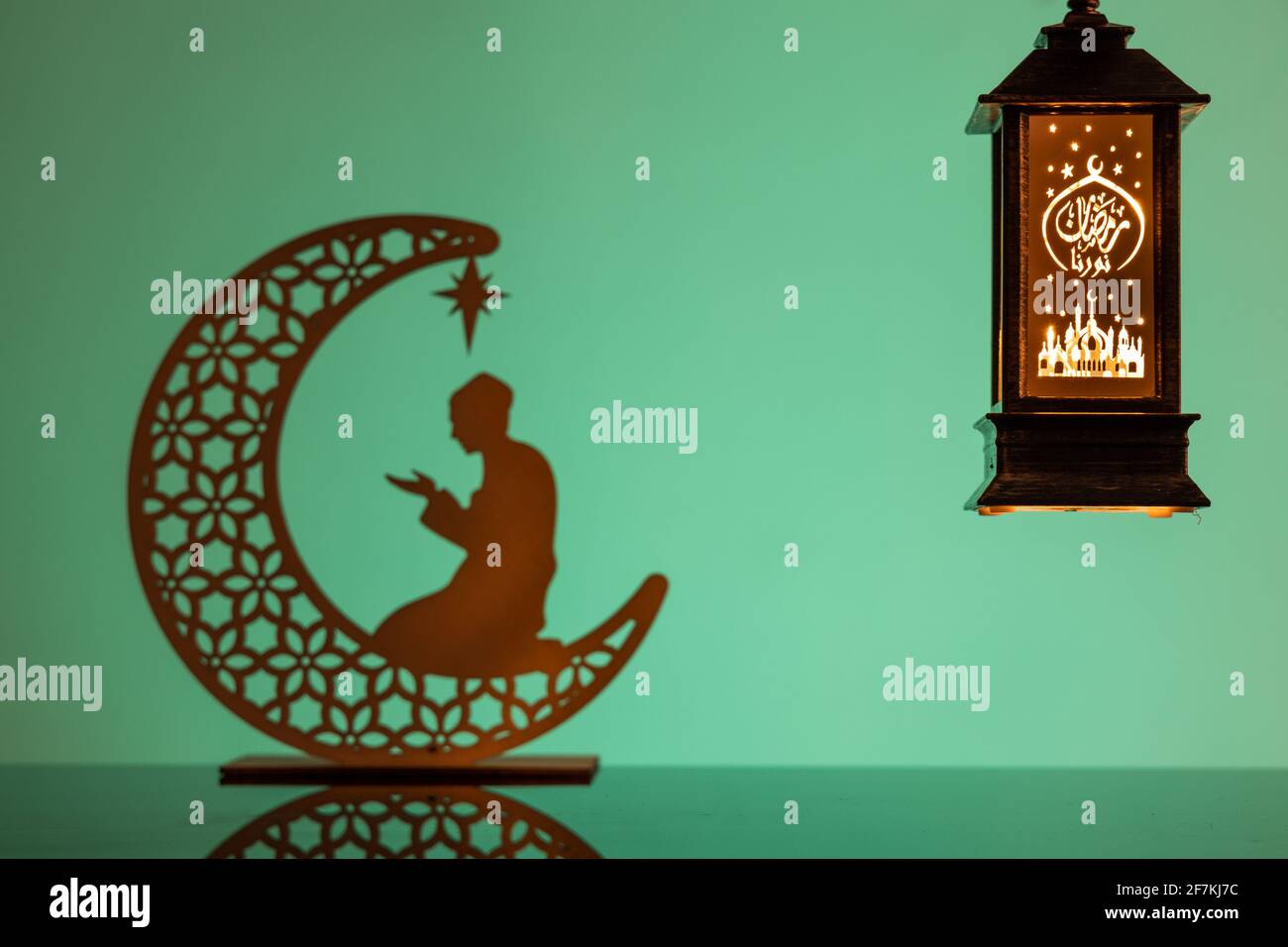 Eid Mubarak Konzepte mit Lampe eingeschrieben mit arabischem Text ins englische übersetzt als Ramadhan ist unser Licht., mit Halbmond in Silhouette Stockfoto