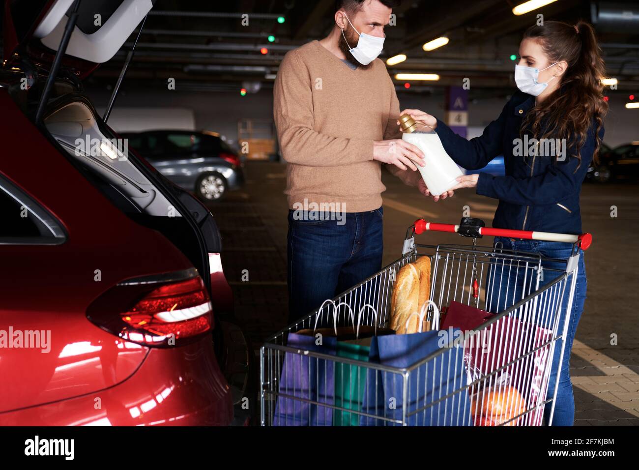 Paar packten ihre Einkäufe während einer Pandemie in ein Auto Stockfoto