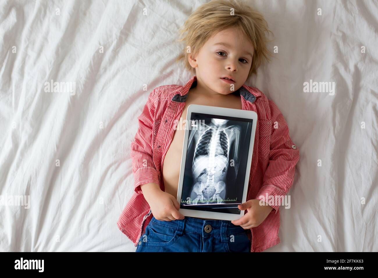 Kleinkind Kind, blonden Jungen, hält Röntgenbild auf Tablette des  Kinderkörpers mit geschluckten Magneten zeigt, Kind schlucken gefährlichen  Gegenstand Stockfotografie - Alamy