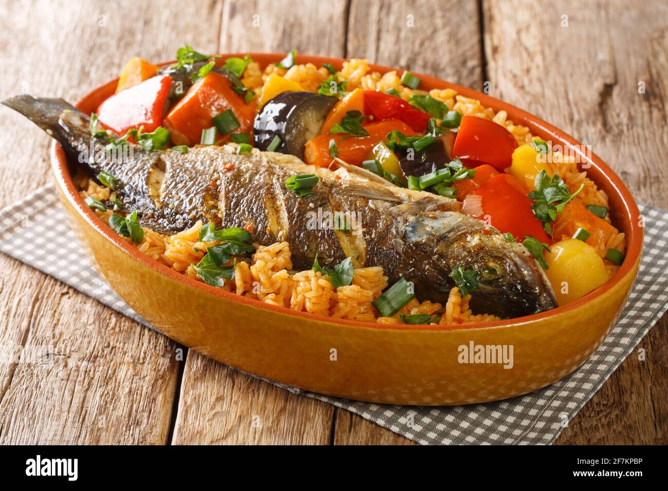 Senegalesischer Reis und Fisch mit Gemüse Thieboudienne Nahaufnahme in der Schale auf dem Tisch. Horizontal Stockfoto
