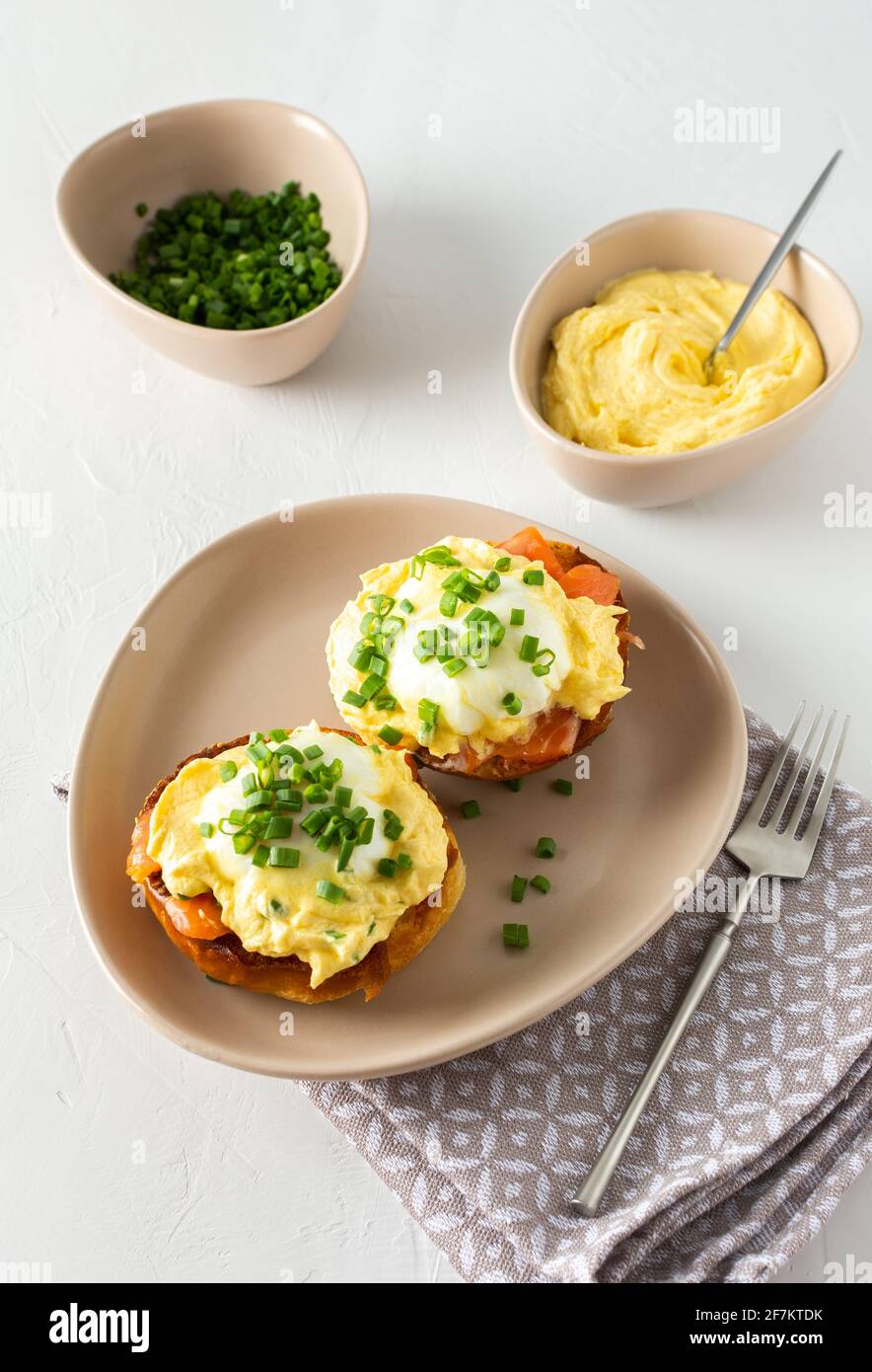Leckeres herzhaftes Frühstück, Eier Atlantic in einem Teller auf weißem Hintergrund, Runde gebratene Brötchen mit Lachs und Eier Benedikt, Sauce Hollandaise Stockfoto