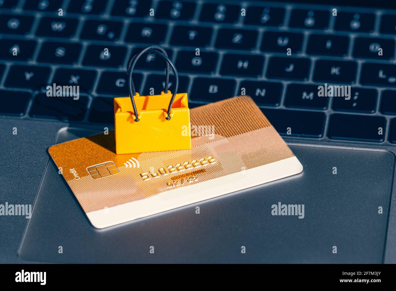 Eine Einkaufstasche liegt auf einer Kreditkarte, die darauf liegt Eine Tastatur Stockfoto