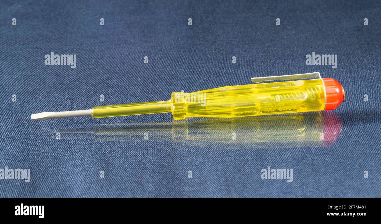 Elektrische Anzeige zur Überprüfung der Spannung.Gelbes Instrument auf dem Tisch Mit Reflexion Stockfoto