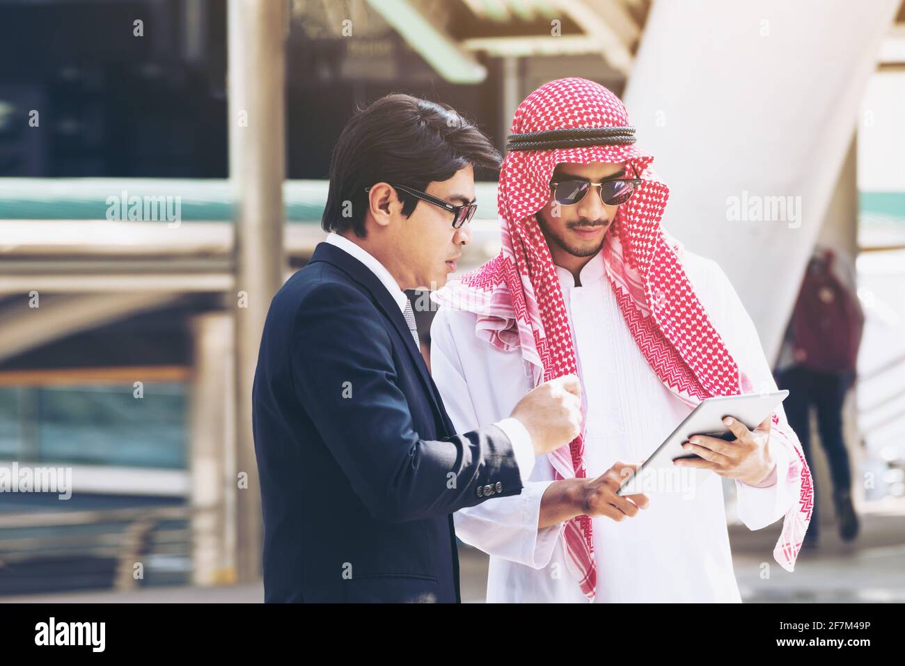 Arabischer Mann und Geschäftsmann diskutieren Inhalte auf dem Tablet-Computer. Multikulturelles internationales Treffen auf dem Seeweg. Stockfoto