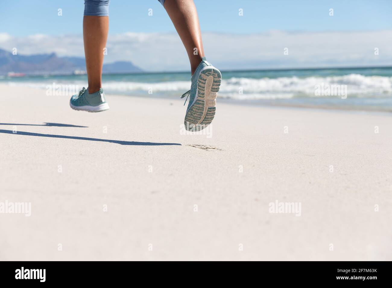 Niedriger Abschnitt der gemischten Rasse Frau beim Training am Strand laufen Stockfoto