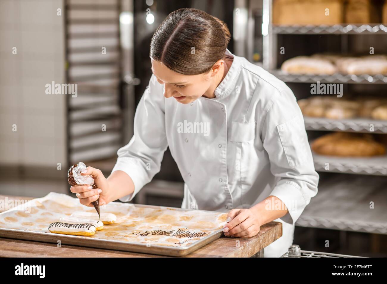 Frau, die die Oberfläche von fertigen Ecolirs schmückt Stockfoto