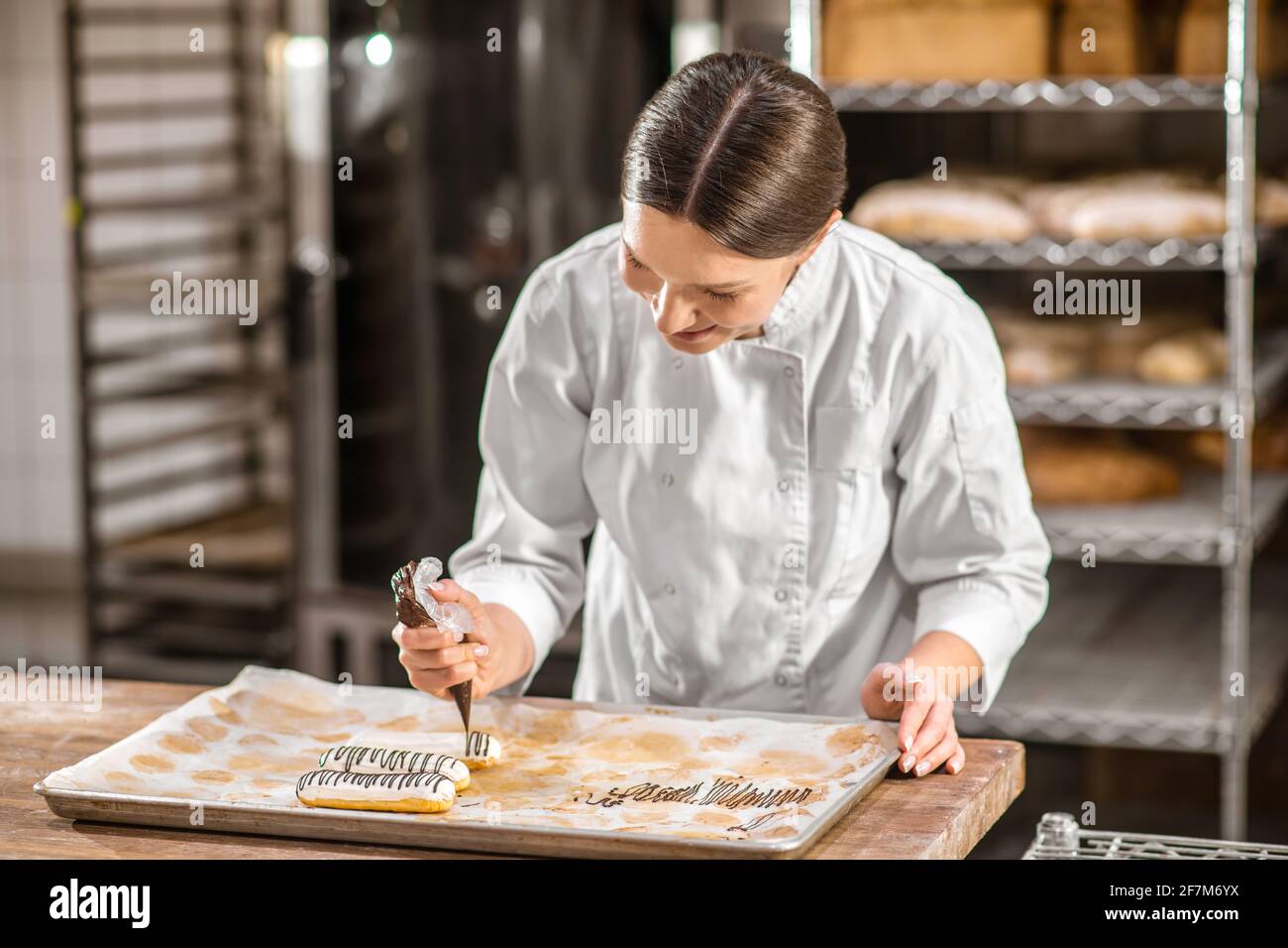 Interessierte Frau Konditorei Dekoration eclairs Stockfoto